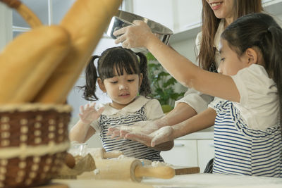 Rear view of mother and daughter in kitchen