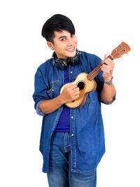 Smiling young man holding guitar against white background