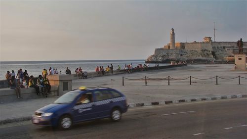 People on beach with city in background