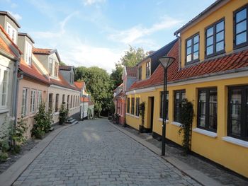 Footpath amidst buildings against sky