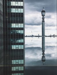 Reflection of buildings on cloudy sky