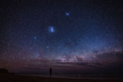 Silhouette of person against star field at night