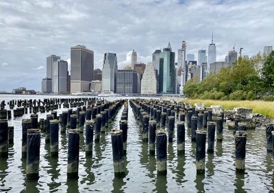 Panoramic view of wooden posts and buildings against sky