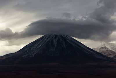 View of snowcapped mountain against cloudy sky