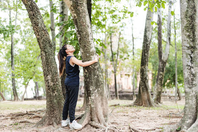 Young woman hugging a big tree, love nature concept.