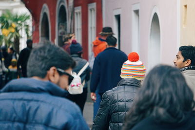 Rear view of people standing in front of building