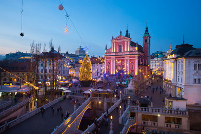 Illuminated buildings in city at dusk