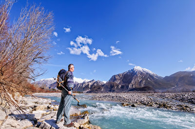 Man standing on mountain against blue sky