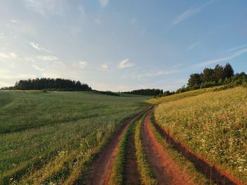 Country road near the slope against the background of the evening sky