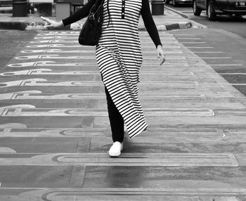Low section of woman standing on street