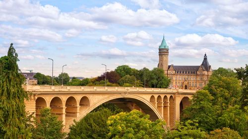 Arch bridge over river against buildings