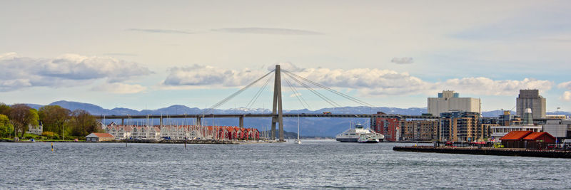 Boats moored at harbor against sky