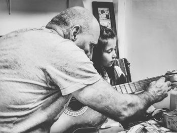 Man playing guitar at home