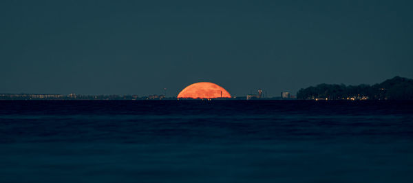 Scenic view of sea against clear sky at night