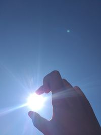 Person hand against bright sun