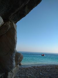 Scenic view of sea and rock formations against clear sky