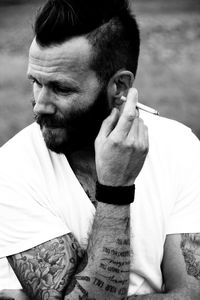 Close-up of man holding cigarette while looking away