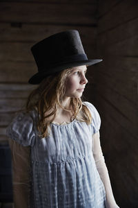 Beautiful young woman in hat looking away