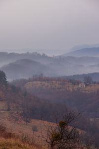 Scenic view of landscape against sky during foggy weather