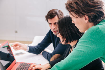 Colleagues brainstorming while looking at laptop office