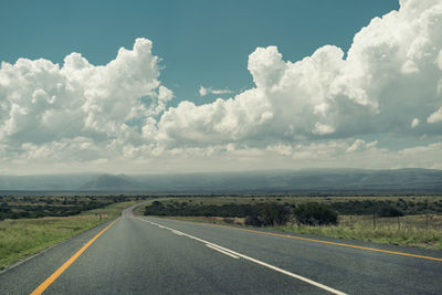 Road passing through land against sky