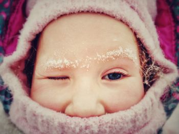 Close-up portrait of cute girl in snow