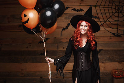 Portrait of young woman with balloons during halloween