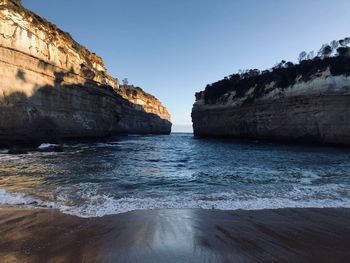 Rocks on beach against clear sky