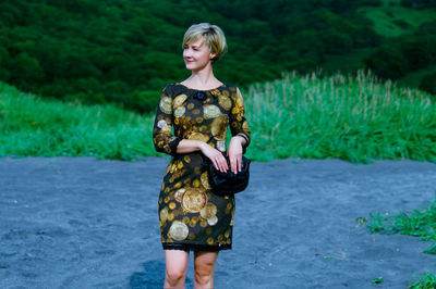 Full length of young woman standing at riverbank