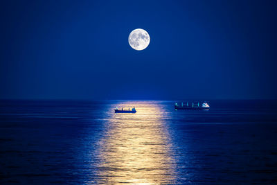 Scenic view of sea against moon at night