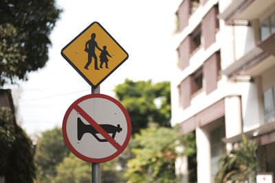 Low angle view of road sign against trees