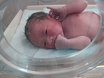 Close-up of baby girl lying on bed