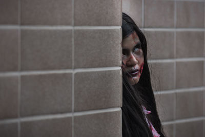 Portrait of woman standing against wall at home