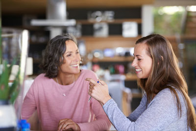 Smiling mother and daughter at cafe