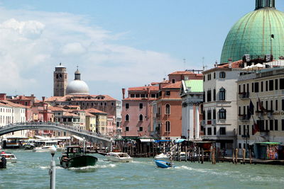 Boats in canal along buildings