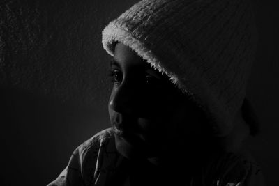 Close-up of smiling boy wearing hat against wall