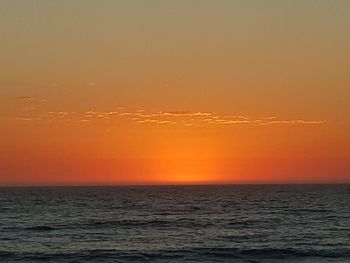 Scenic view of sea against orange sky