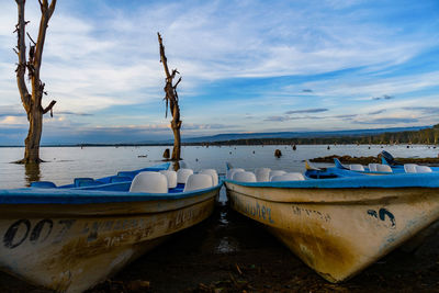 Boats moored on beach against sky