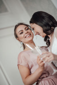 Bridesmaid and bride holding champagne flute