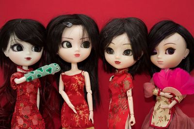 Close-up of dolls against red background