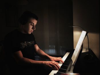 Young man playing piano at home