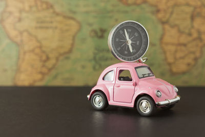Close-up of toy car and navigational compass on table