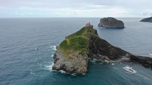 Scenic view of rock formation in sea against sky