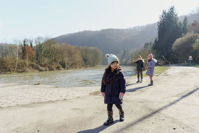 Kids walking on road against sky