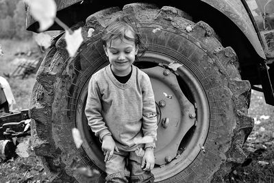Playful boy leaning on tire