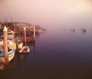 Boats in sea at sunset