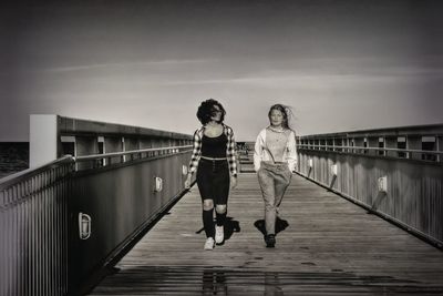 Full length of woman on footbridge against sky