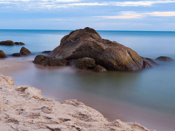 Scenic view of rocks in sea against sky