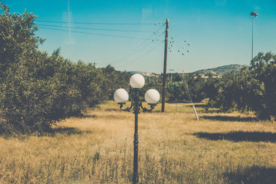 Street light on field against sky