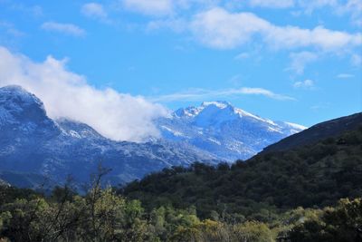 Scenic view of mountains against blue sky